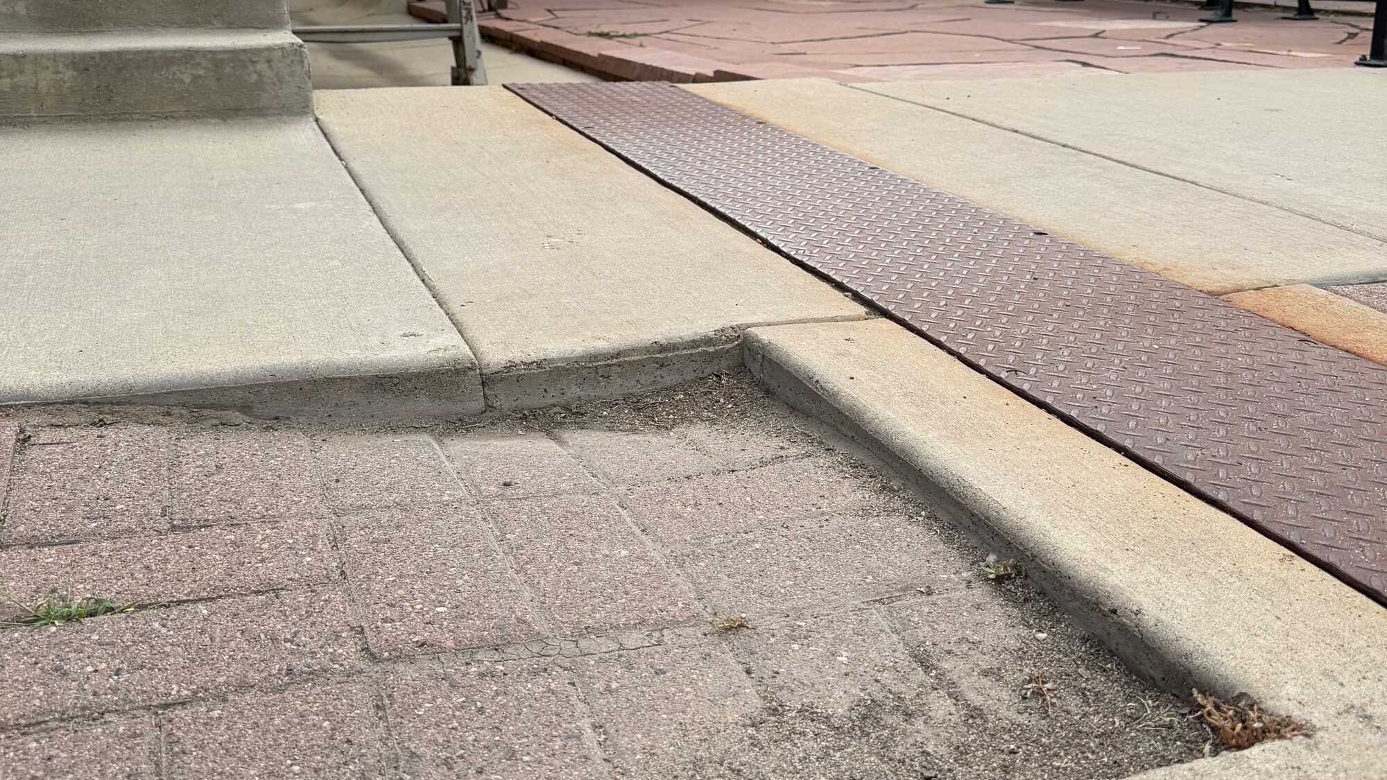 A raised, uneven lip in a downtown Niwot sidewalk where the concrete steps up abruptly.