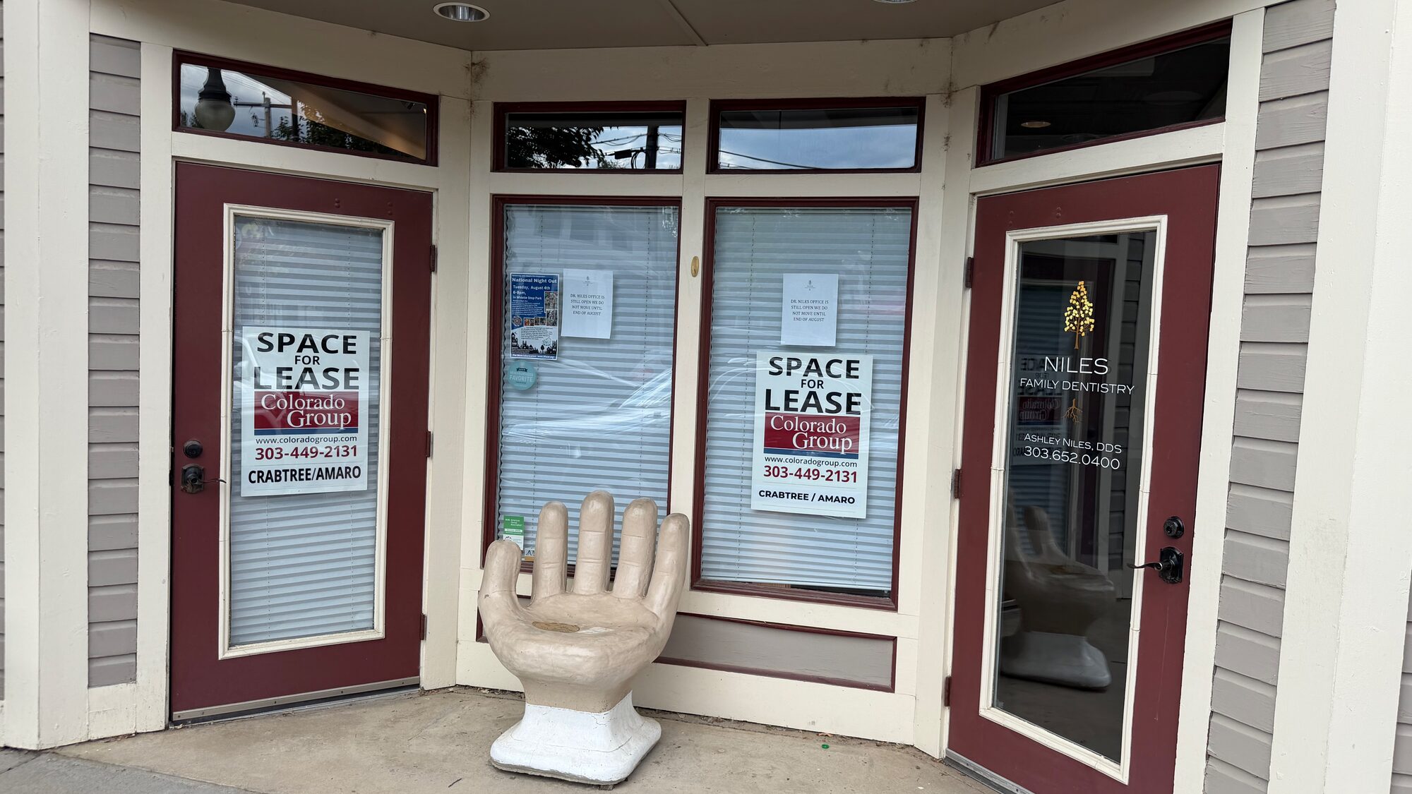 A vacant downtown Niwot storefront with 'space for lease' signs in the windows.