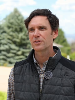 Kevin Klau, on a Niwot street with the foothills behind him.