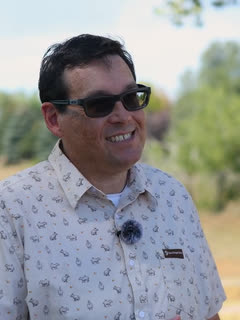 Scott Firle, laughing, at the edge of an open field.